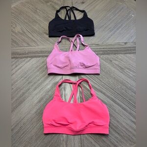 lululemon black, light pink, and dark pink sports bras